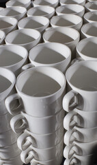Many white coffee cups are stacked in a pile, pattern