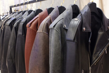 different leather biker jackets on hangers on clothing rail
