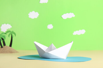 Creative composition with white origami boat on color background