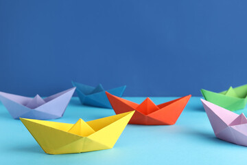 Colorful origami boats on color background