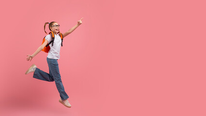Energetic girl jumping with joy and pointing up