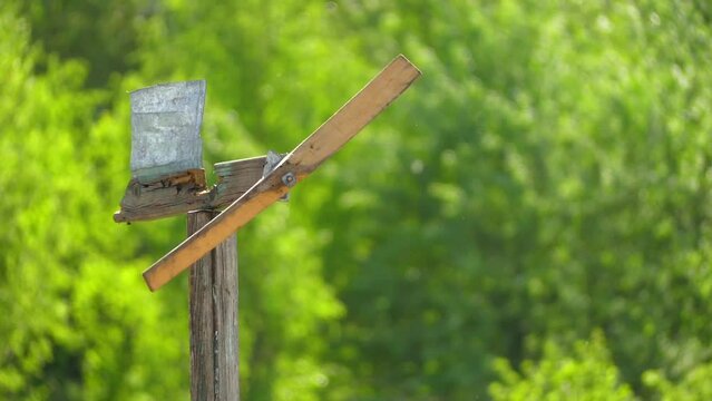 Wooden homemade weathervane turns winding blades