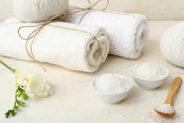 Composition with spa accessories, sea salt and freesia flowers on light table