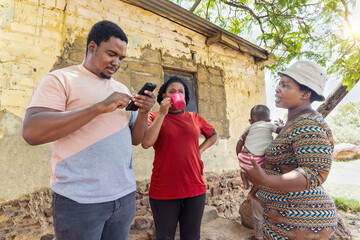 african social worker volunteer with a phone educating the villagers in a remote village in...
