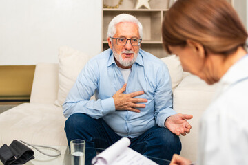 Female doctor examining older senior man in doctor office or at home. Old man patient and doctor have consultation in hospital room. Medicine healthcare medical checkup. Visit to doctor