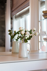 Bouquet of flowers in a vase in front of a mirror in the bedroom. Interior details.	