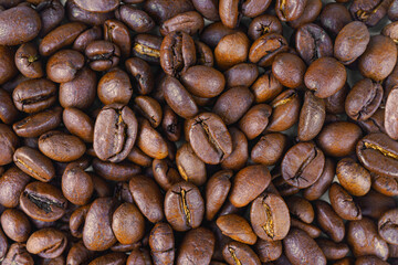 Aromatic roasted arabica coffee bean close up, macro. Wallpaper, texture, background, top view.