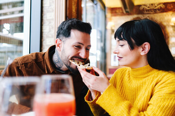 Joyful Couple Laughing While Eating Pizza Together