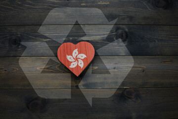 wooden heart with national flag of hong kong near reduce, reuse and recycle sing on the wooden...