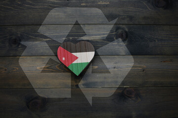 wooden heart with national flag of jordan near reduce, reuse and recycle sing on the wooden...