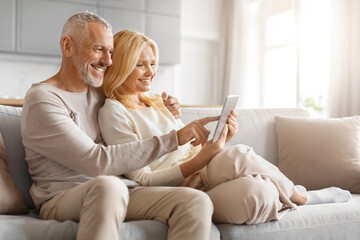 Affectionate couple using tablet on couch
