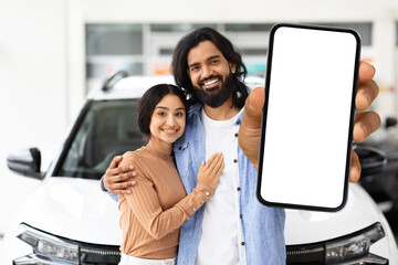 Couple showing phone with car dealership