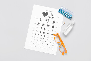 Stylish eyeglasses with eye test chart, tweezers and solution for contact lenses on white background