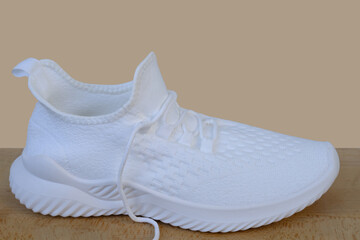 white summer sneakers close-up, female hands test shoes on light background, tie shoelaces, Shoe...
