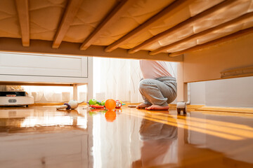 Children's room with a playing baby taken from under the crib