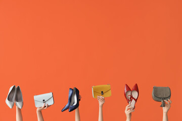 Women with stylish bags and shoes on orange background