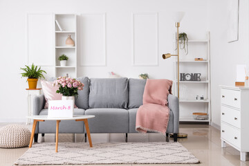 Interior of living room with roses in vase and card for International Women's Day