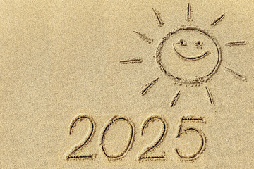  Drawing sun and 2025 on the sandy beach of the coastline as a symbol of the beach season - 767457227