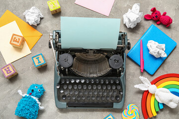 Vintage typewriter and knitted toys on grunge background