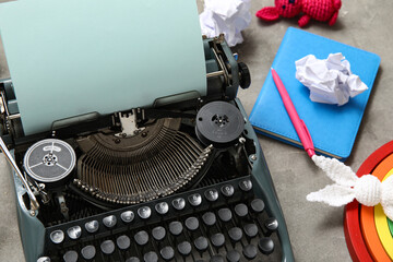 Vintage typewriter and toys on grunge background