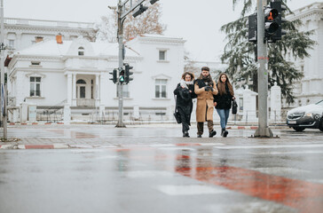 Young, creative, business people walking together on a snowy city street.