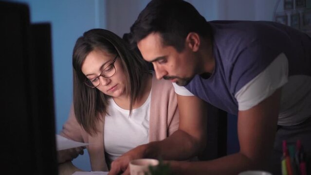 A couple sitting by the computer and working on personal finance at home

