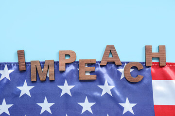 Wooden letters spelling word IMPEACHMENT and USA flag on blue background