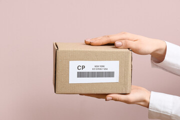 Woman holding many cardboard package with label and barcode on pink background