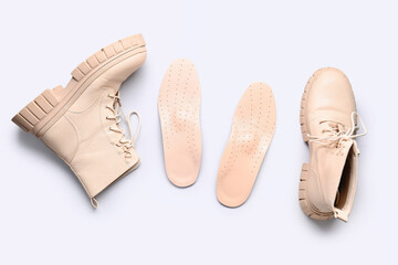 Boots and leather orthopedic insoles isolated on white background