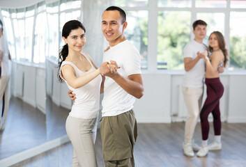 Girl paired up with young man, they train to perform slow waltz dance, rehearse performance....