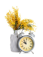 Alarm clock and vase with mimosa flowers on white background
