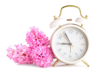 Alarm clock and hyacinth flowers on white background