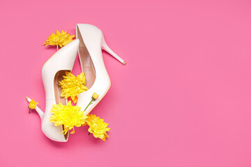 Female high heeled shoes and chrysanthemum flowers on pink background