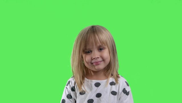 Portrait of a smiling girl with a green screen in the background