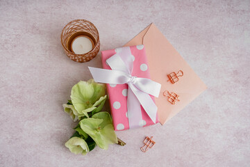 Gift box with beautiful flowers, envelope and candle on white background