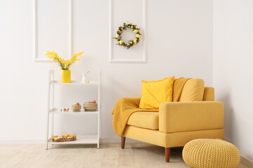 Sofa with shelving unit, Easter wreath and decor near white wall