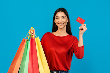 Woman Holding Bright Shopping Bags And Credit Card