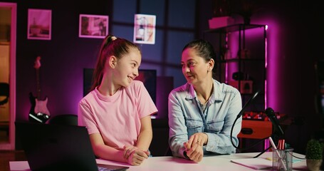 Daughter and mother filming reaction video for gen Z audience, preparing to look at online videos...