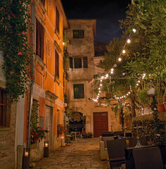 Old street in Porec town illuminated by lamps at the evening, Croatia, Europe