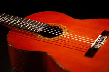 Classical Spanish flamenco guitar close up, dramatically lit isolated on black background with copy...