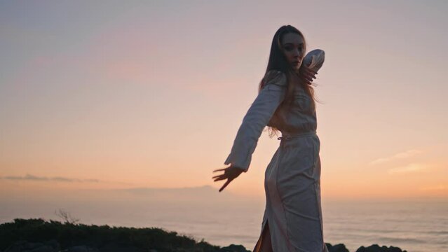 Dancer woman raising hands dancing sunset summer shore. Girl moving gracefully