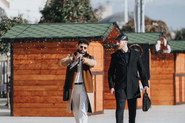 Stylish men walking confidently in urban setting with bags and gadgets.