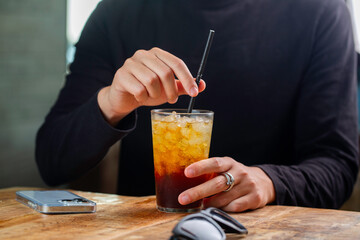 Person at Table with Iced Cola, Phone and Sunglasses