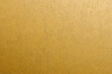 A gold colored wall with a patterned texture