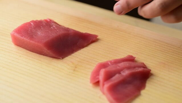 sushi chef slicing tuna sashimi