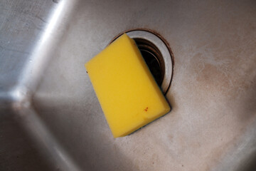 A yellow spoon in the kitchen sink, kitchen washing equipment.