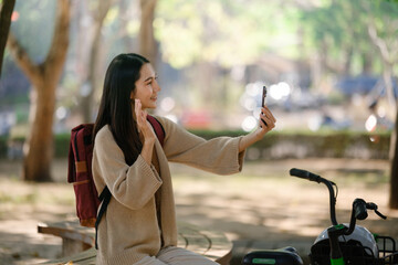 Beautiful woman taking a bike stroll in the park, business woman holding smartphone using bike rental, business woman holding smartphone using bike rental digital phone.