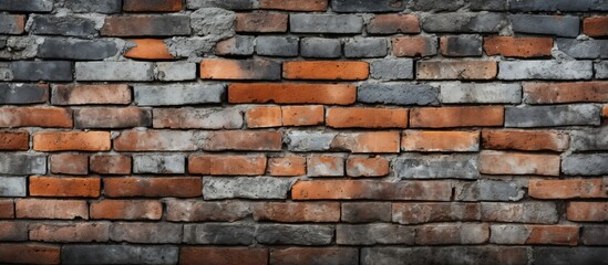 Fototapeta premium A detailed closeup of a brick wall showcasing the intricate brickwork and composite material. The building facade features a pattern of rectangular bricks, creating a visually appealing design