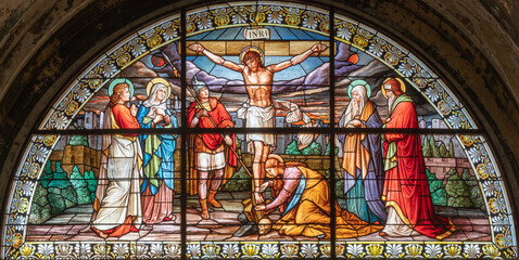 MILAN, ITALY - MARCH 4, 2024: The crucifixion in the stained glass in the church Basilica di Santo Stefano Maggiore by Costante Panigati (1898).