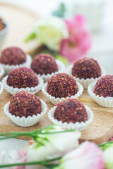 Homemade Chocolate Energy Balls Sprinkled With Dried Berries on Wooden Board, Healthy food
